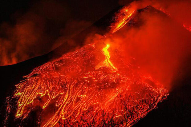 Etna chrlící lávou osvětluje noční oblohu